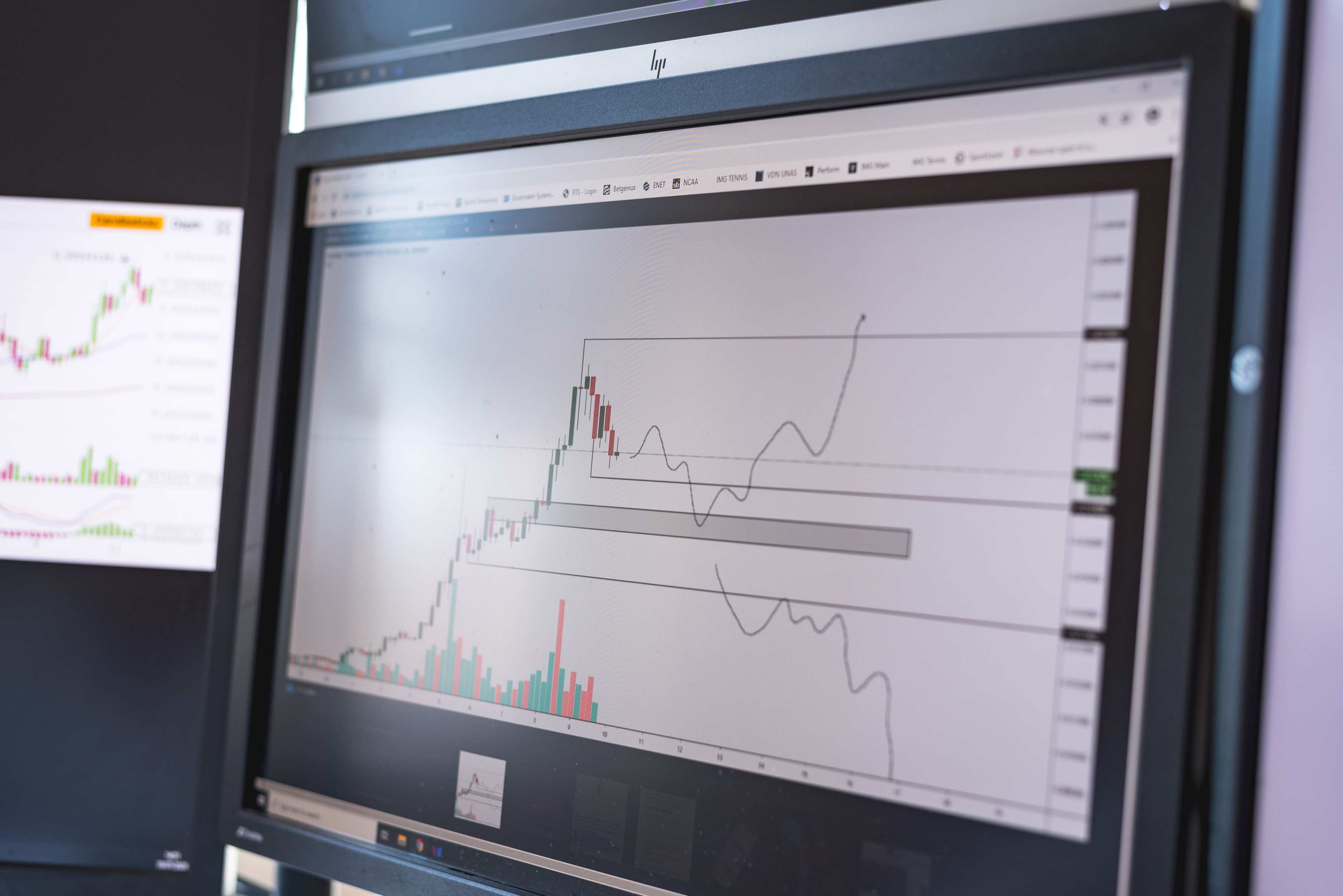 Bildschirm mit Diagrammen und Marktanalyse in abgedunkeltem Raum